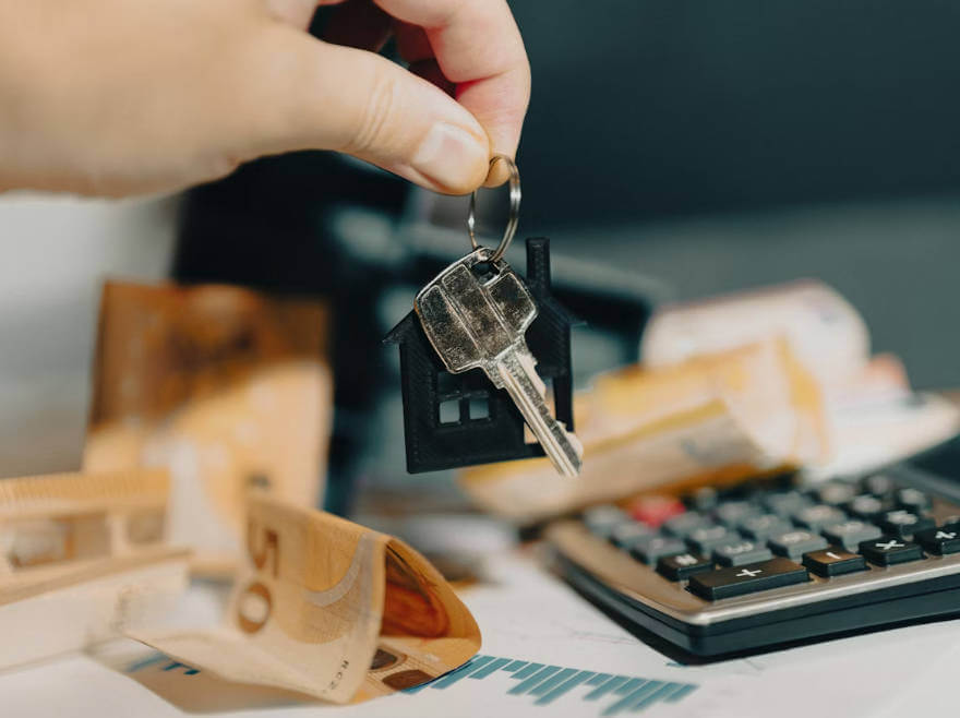 주택담보대출 금리 비교를 위해 집 열쇠와 계산기를 확인하는 사진