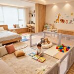 17개월 아기 독서존과 놀이존이 있는 따뜻한 집 인테리어. 거실에 낮은 책장, 빈백 소파, 부드러운 장난감과 그림책이 배치된 아기 전용 공간